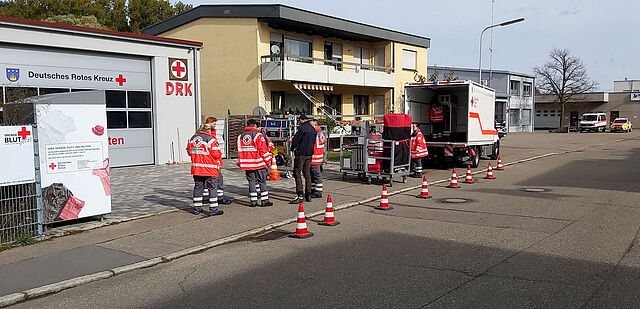 Hintergrund ein DRK-Ortsvereinsgebäude, im Vordergrund Übungsszenario.