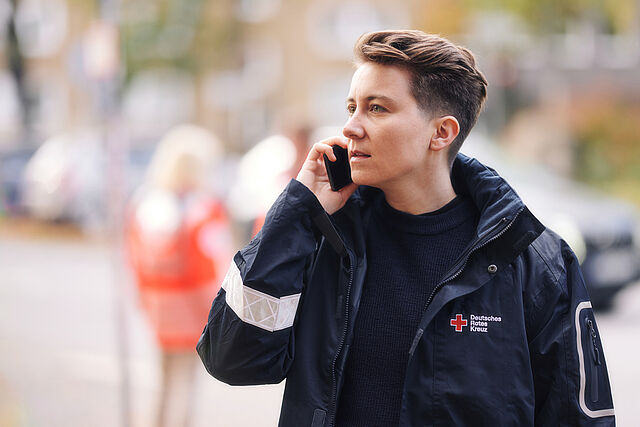 DRK-Mitarbeiterin telefoniert am Handy.